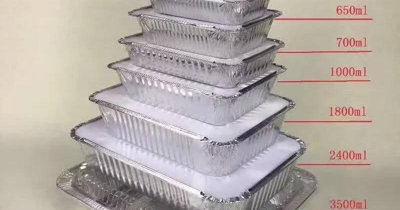 Stacked rectangular aluminum takeout containers with board lids
